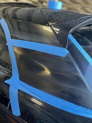 Close-up of window film being fitted on a black vehicle