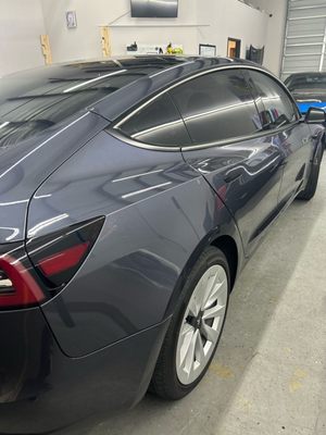 Gray sedan with dark tinted windows inside the shop